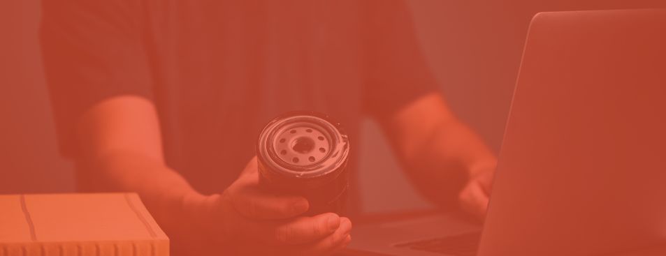 Businessman holding automotive oil filter in hand and buying on online marketing website and social media store form laptop computer.